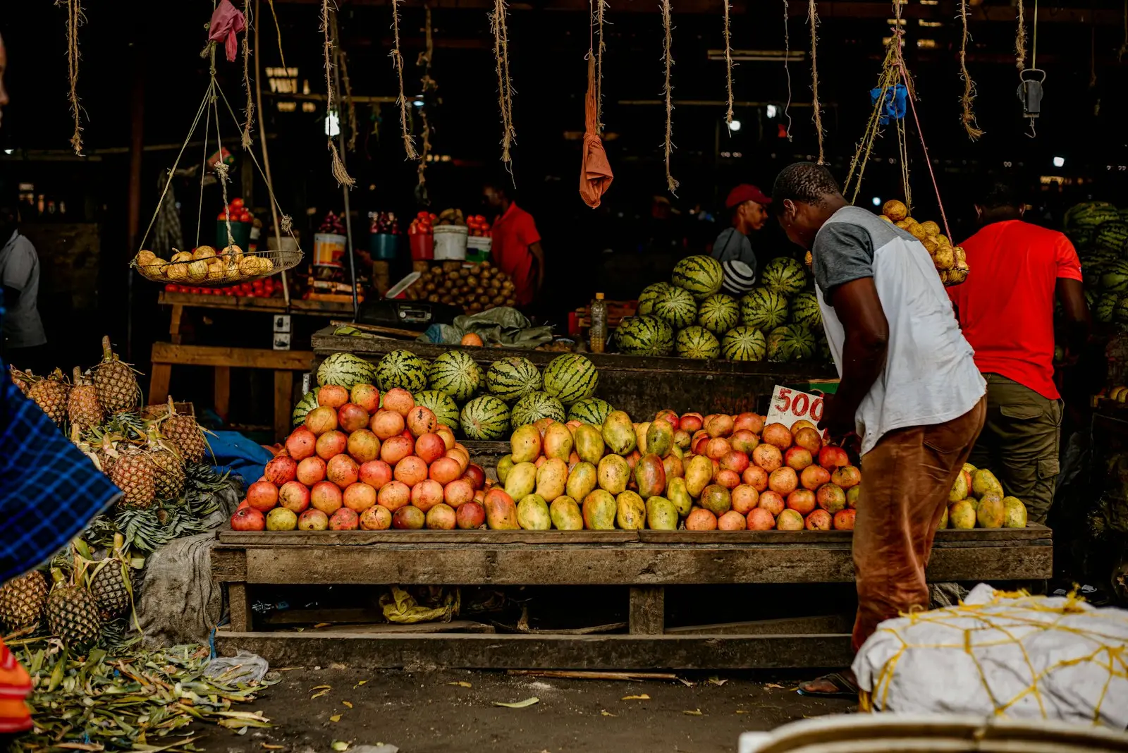 A trader at a fruit stall in a covered market